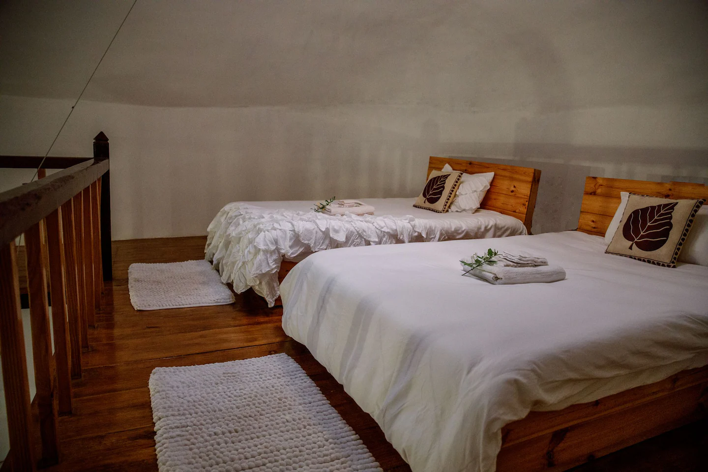 Loft twin bedroom with white bedding and wooden floors