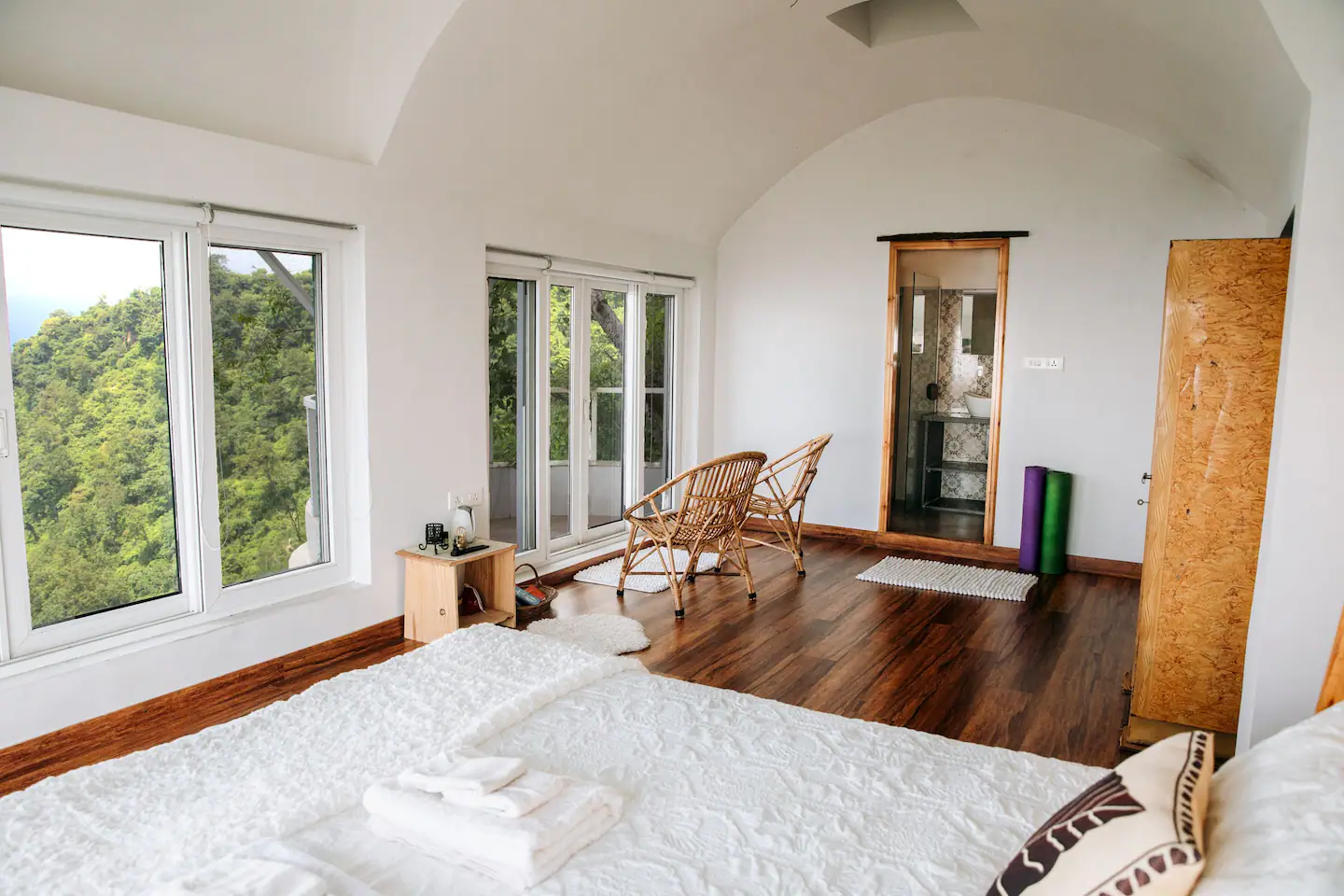 Master suite with panoramic forest views and arched ceiling